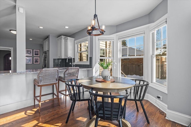 dining space featuring baseboards, a chandelier, wood finished floors, and recessed lighting