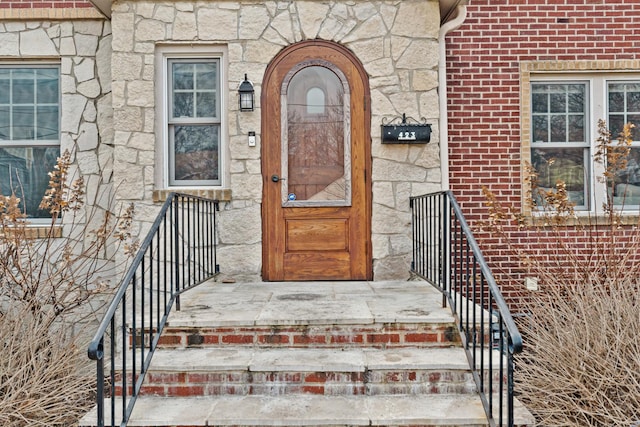 entrance to property with stone siding and brick siding