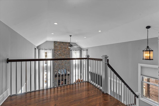 hall featuring lofted ceiling, recessed lighting, wood finished floors, and an upstairs landing