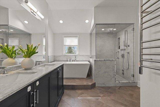 full bath featuring lofted ceiling, a freestanding bath, a sink, and a shower stall