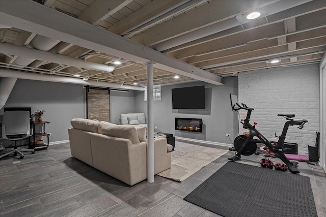 interior space with brick wall, a glass covered fireplace, and baseboards