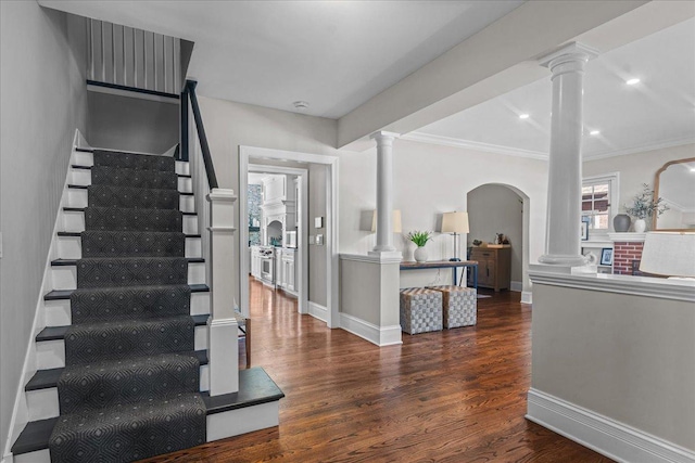 interior space featuring decorative columns, baseboards, and wood finished floors