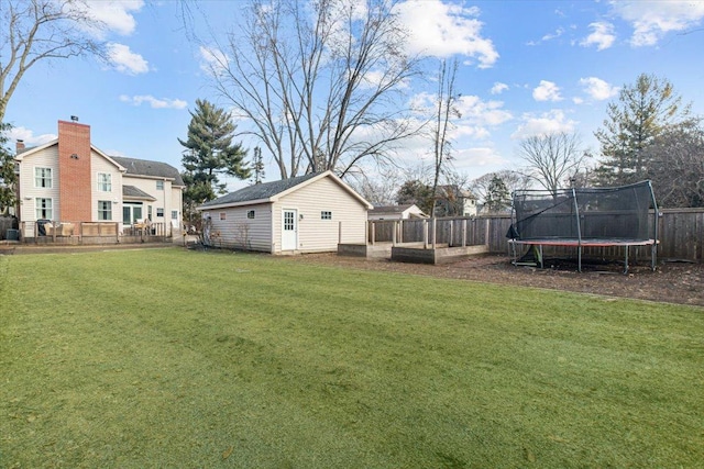 view of yard with a fenced backyard, a trampoline, and an outdoor structure