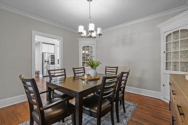 dining room featuring dark wood-type flooring, crown molding, and baseboards