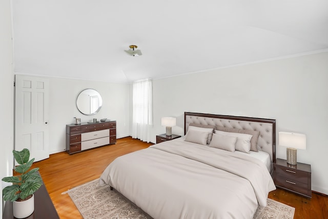 bedroom with crown molding and hardwood / wood-style floors