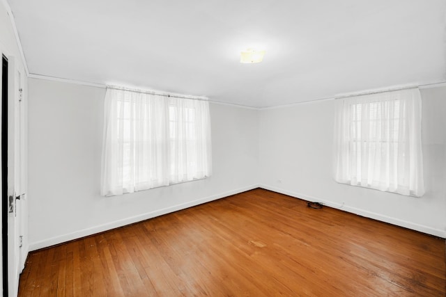 unfurnished room with hardwood / wood-style flooring and a healthy amount of sunlight