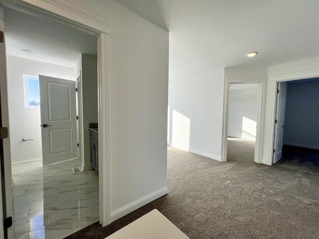 corridor featuring dark colored carpet