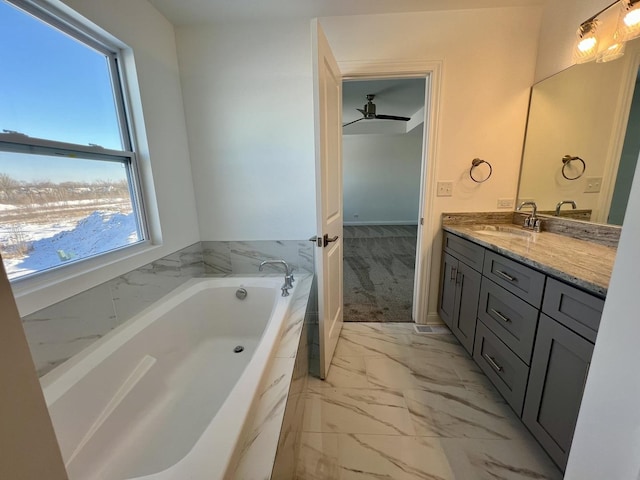 bathroom featuring ceiling fan, vanity, and a bath