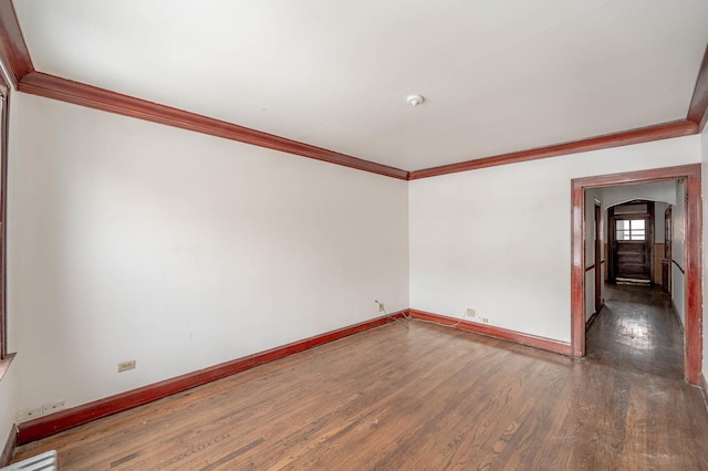 spare room featuring dark hardwood / wood-style flooring and crown molding