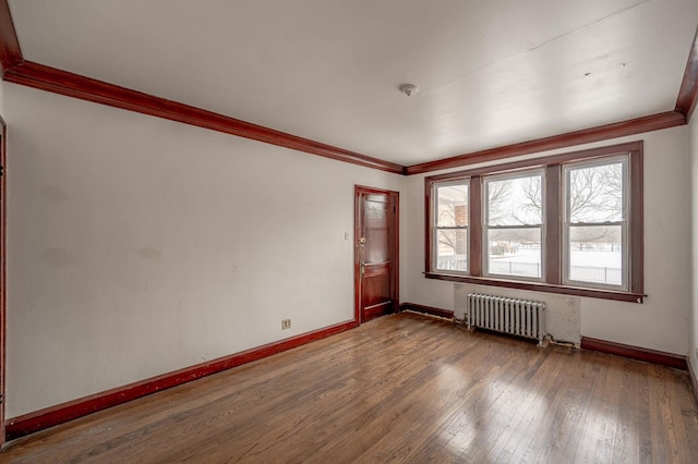 unfurnished room with radiator, hardwood / wood-style flooring, and ornamental molding