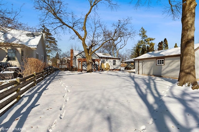 yard covered in snow featuring an outbuilding