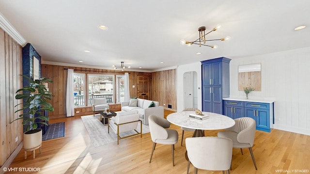 dining space featuring crown molding, a chandelier, and light hardwood / wood-style floors