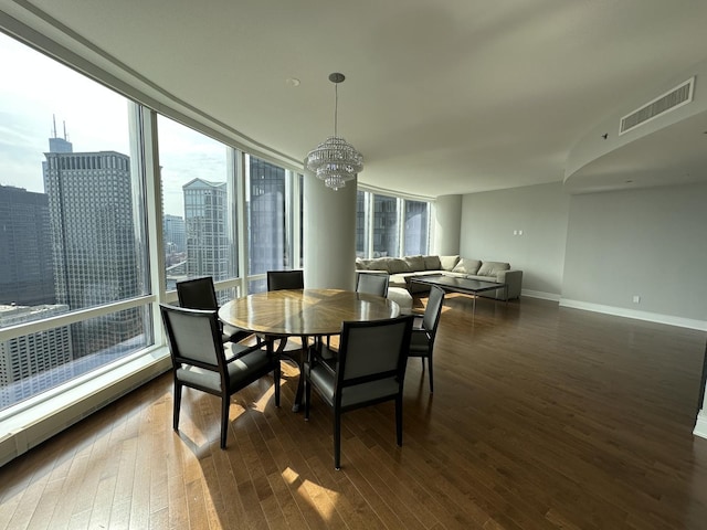 dining space featuring dark wood-style flooring, visible vents, and a city view