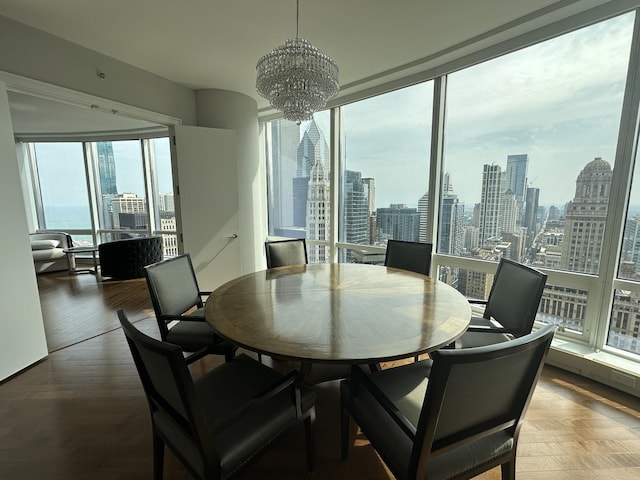 dining room with an inviting chandelier, wood finished floors, and a city view