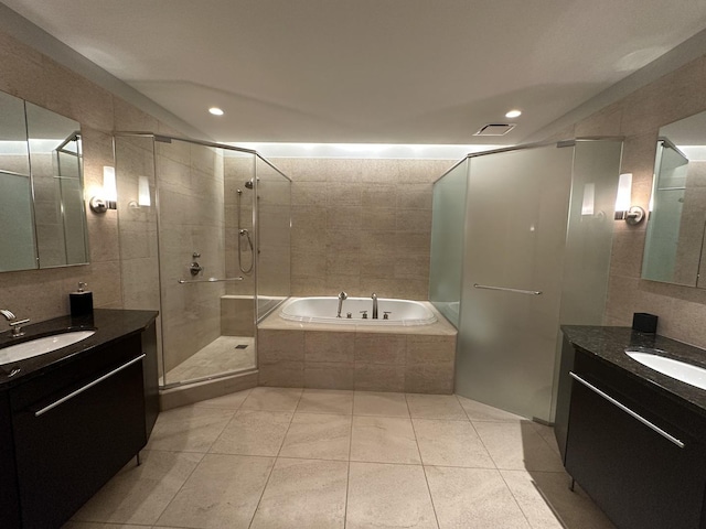 full bathroom with a garden tub, a sink, tile walls, and a shower stall