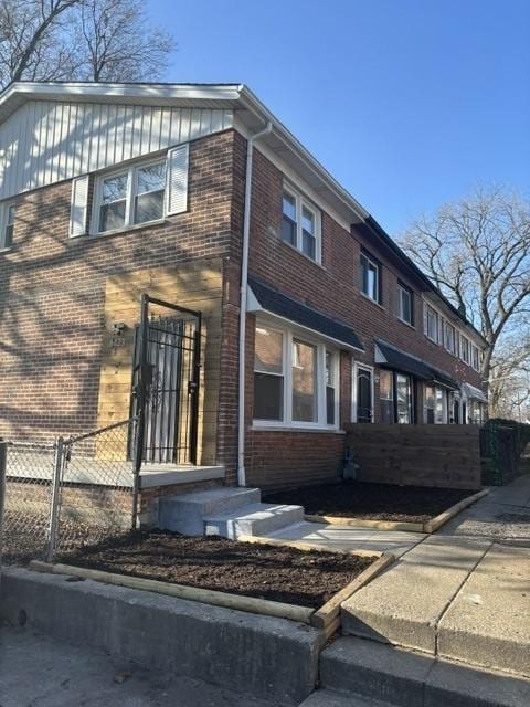 view of front of house with brick siding and fence