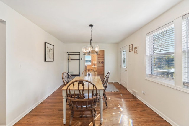 dining room featuring dark hardwood / wood-style floors and a chandelier