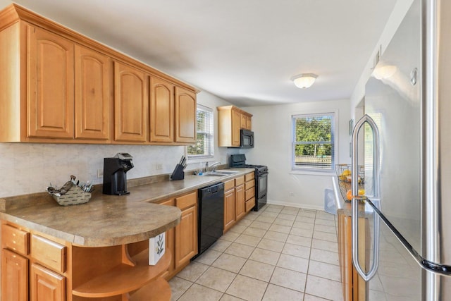 kitchen featuring sink, light tile patterned floors, and black appliances