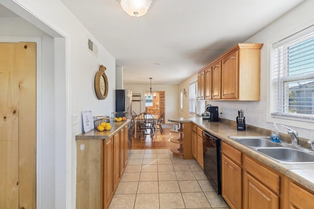 kitchen featuring decorative light fixtures, black dishwasher, sink, and light tile patterned floors