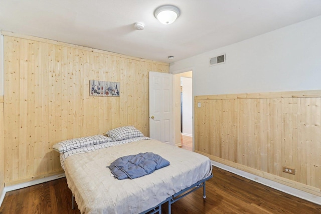 bedroom featuring dark hardwood / wood-style floors and wood walls