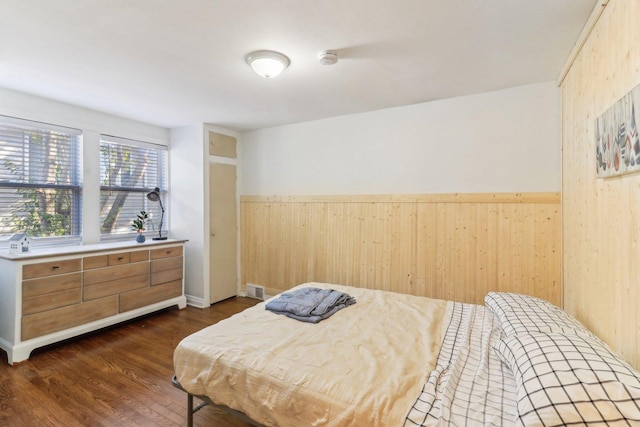 bedroom featuring dark hardwood / wood-style floors and wood walls