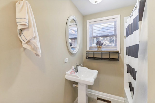 bathroom featuring tile patterned floors and shower / bath combo with shower curtain