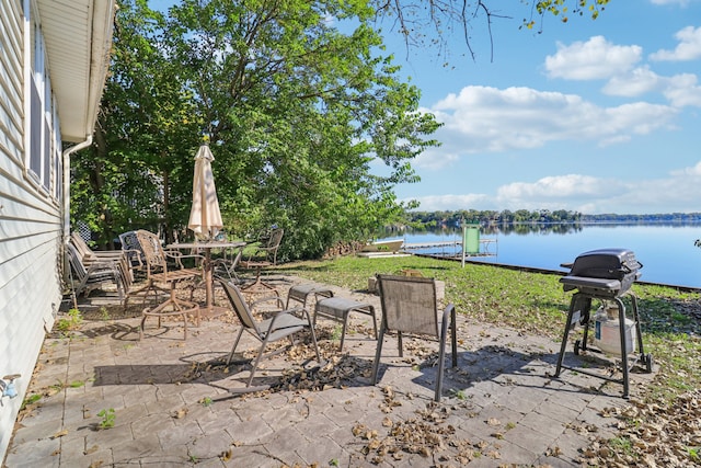 view of patio with a water view and a grill