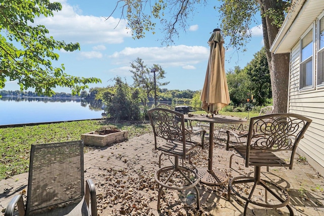 view of patio with a fire pit and a water view