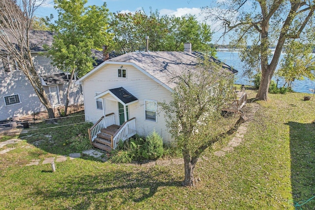 view of front of house featuring a front lawn and a water view