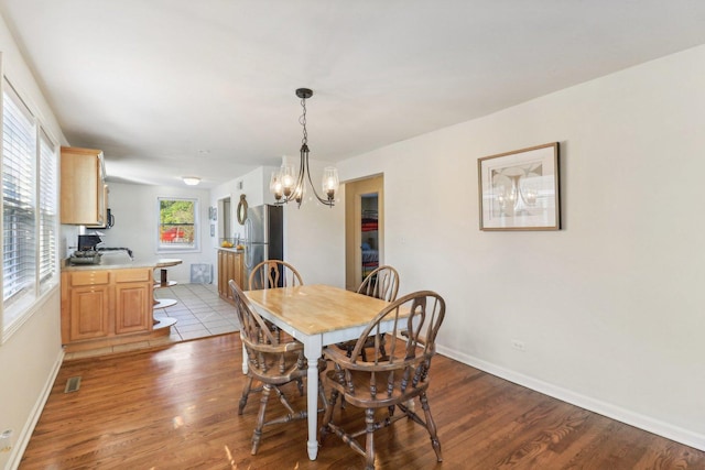 dining space with an inviting chandelier and light hardwood / wood-style floors