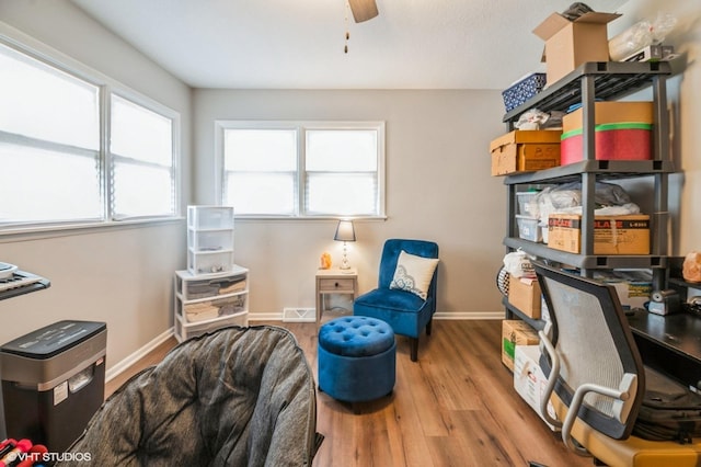 office space featuring visible vents, ceiling fan, baseboards, and wood finished floors