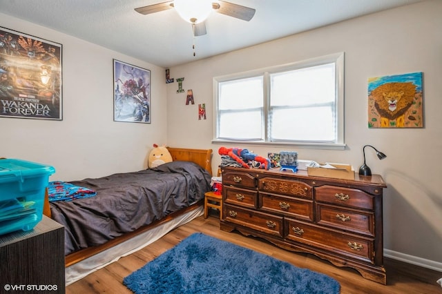 bedroom with ceiling fan, baseboards, and wood finished floors