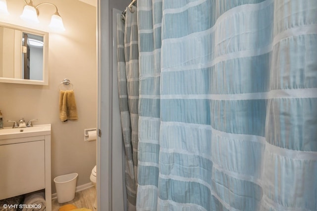 full bathroom with curtained shower, vanity, and toilet