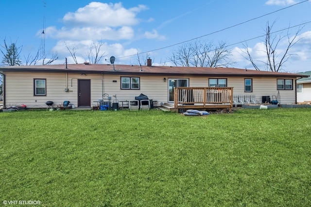 rear view of house featuring a deck and a lawn