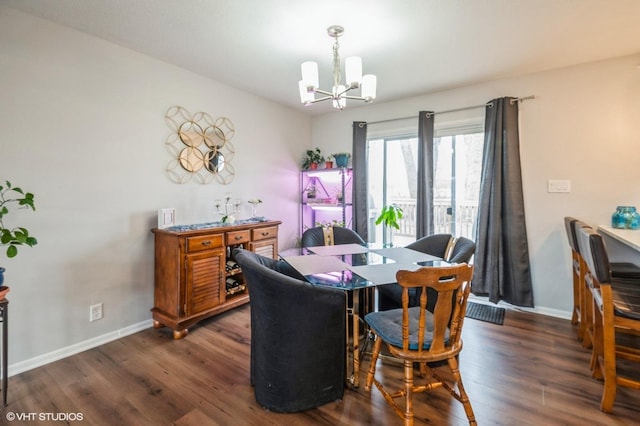 dining room featuring wood finished floors, baseboards, and an inviting chandelier