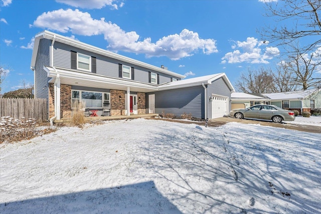 traditional-style home featuring brick siding, an attached garage, and fence