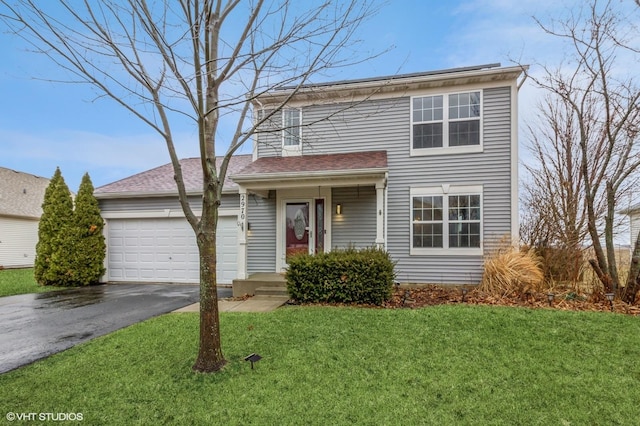 traditional-style house with driveway, a garage, and a front lawn