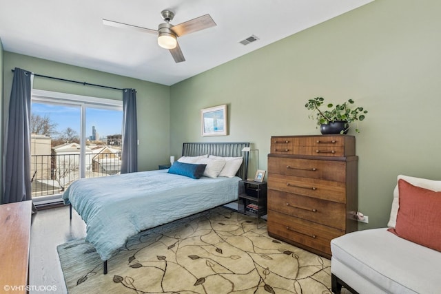 bedroom featuring access to exterior, visible vents, and a ceiling fan