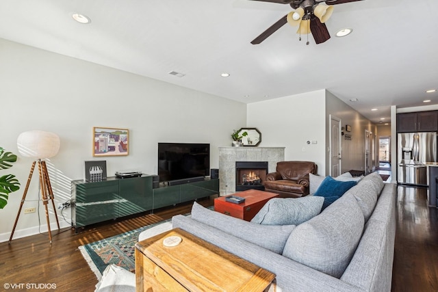 living room with dark wood-type flooring, recessed lighting, visible vents, and a tiled fireplace