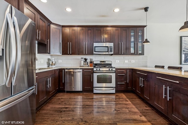 kitchen featuring appliances with stainless steel finishes, dark wood finished floors, dark brown cabinetry, and tasteful backsplash