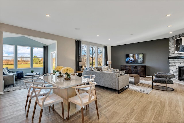 dining room with a fireplace and light hardwood / wood-style flooring