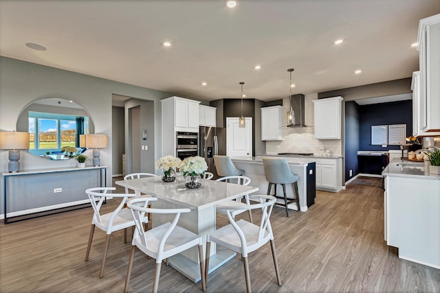 dining area with sink and light hardwood / wood-style flooring