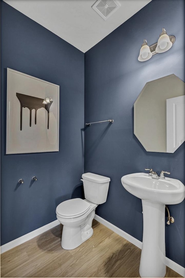 bathroom featuring wood-type flooring and toilet