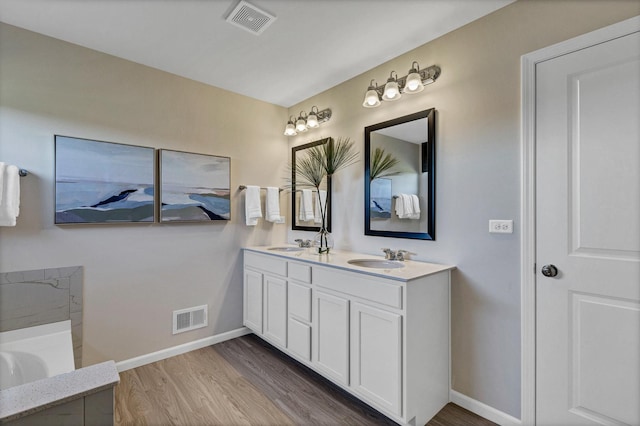 bathroom featuring a tub to relax in, vanity, and hardwood / wood-style floors