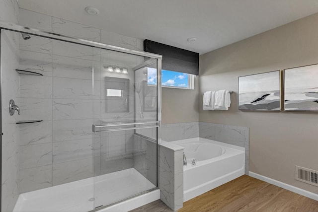 bathroom with hardwood / wood-style floors and separate shower and tub