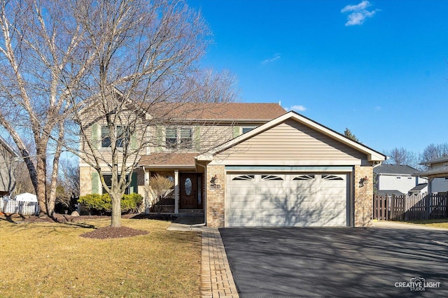 traditional-style home with driveway, an attached garage, fence, and brick siding