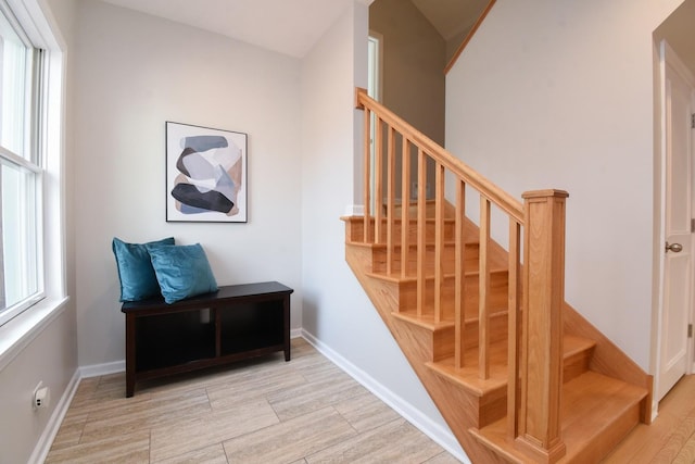 stairway with baseboards and wood finished floors