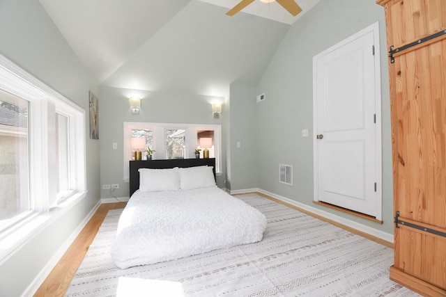 bedroom featuring lofted ceiling, light wood-style floors, baseboards, and visible vents