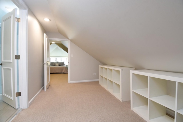 additional living space featuring carpet, baseboards, and vaulted ceiling