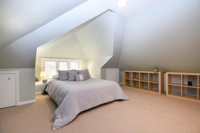 carpeted bedroom with lofted ceiling and baseboards